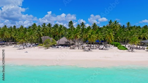 Tropical resort palm beach on the Caribbean coast. Palm trees, white sand, and turquoise sea—the perfect landscape for a summer vacation or a holiday banner. A beautiful tourist destination.