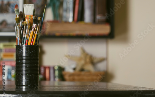 Assorted bristle brushes stand upright in a ribbed container
