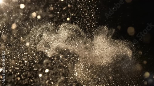 Swirling dust particles in motion against a dark background
