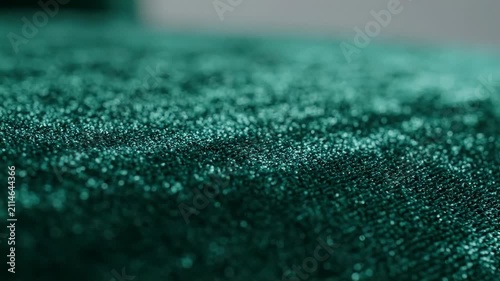 Teal fabric with a shimmering textured surface in closeup