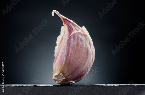 Single Garlic Clove with Skin on Dark Background