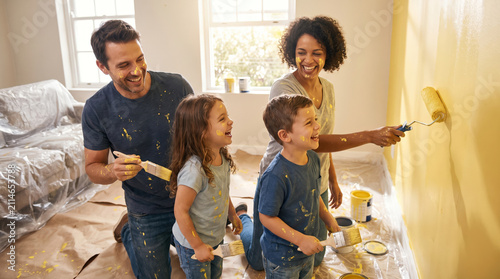 Family painting a room together during a home improvement project on a weekend