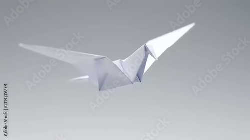 White Paper Crane Flying Through Grey Sky.