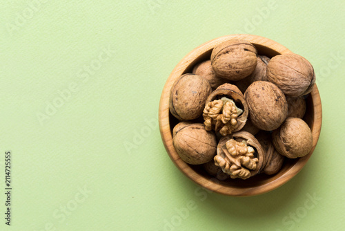 Fresh healthy walnuts in bowl on colored table background. Top view Healthy eating bertholletia concept. Super foods