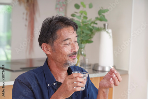 内服薬を飲もうとするシニア男性