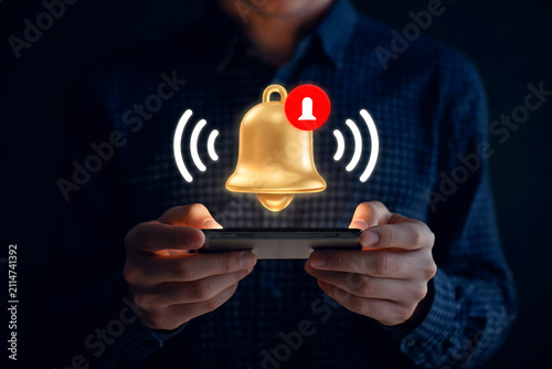 Person holding smartphone Notification bell icon with red dot appears above screen Alert reminder message urgent important
