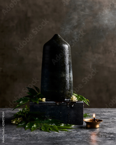 Premium Black Shiva Lingam with Bilva Leaves and Oil Lamp Devotional Still Life