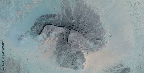 Obraz na plátně Satellite view of a hazy desert basin in the Sahara Desert North Africa where dendritic canyons meet dune fields under drifting dust