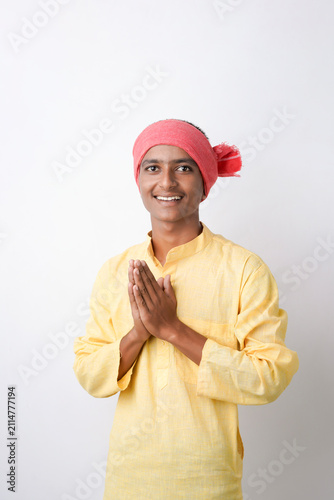 Foto Young indian farmer doing namaste on white background