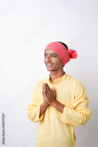 Fotografía Young indian farmer doing namaste on white background