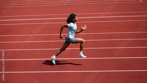Bild auf Leinwand Black teenage female runner practicing sprint strides on outdoor athletics track