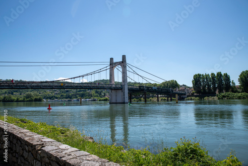 Fotografie Suspension Bridge Over the rhone River With Green Riverbank near condrieu