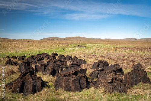 A warm, sunny HDR landscape image of freshly dug peat drying in the summer sunshine in Strathnaver, Sutherland, Scotland