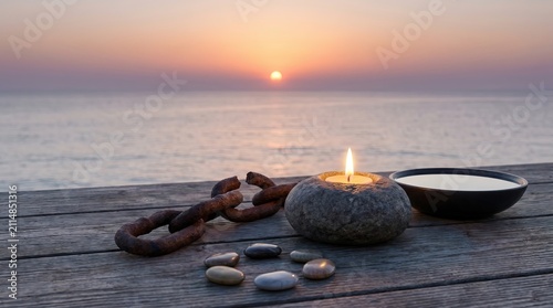 Tranquil Sunset with Candle and Stones by the Ocean