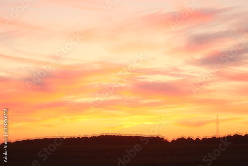 Canvastavla A beautiful sunset casting vibrant orange and pink hues across the sky over a si