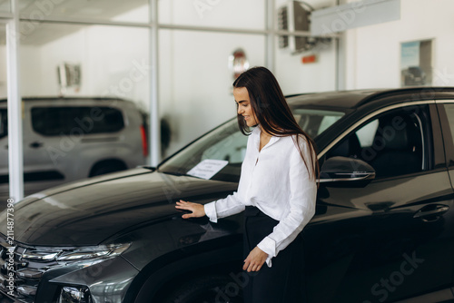 Woman exploring new car at dealership showroom