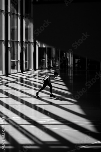 Person skateboarding in a sunlit hall. Urban skater riding in a modern architectural space.