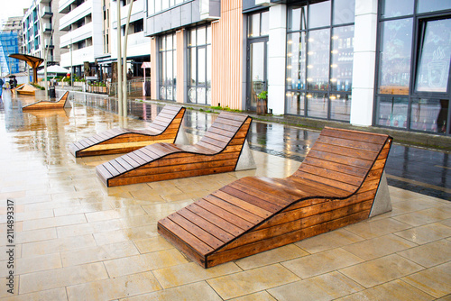 Obraz na płótnie Empty wet deck chairs by beach in rain