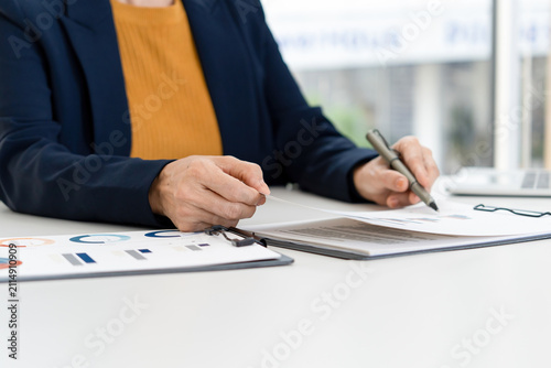 Close Up of Businesswoman Hands Reviewing Financial Documents at Desk