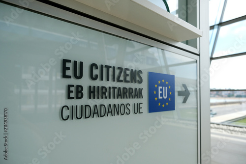 Mehrsprachiges Hinweisschild mit der Aufschrift „EU Citizens“ in Englisch, Baskisch und Spanisch sowie Europaflagge und Richtungspfeil am Kreuzfahrtterminal im Hafen von Getxo bei Bilbao, Spanien