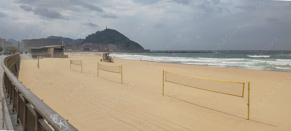 Fototapeta premium Vista general de la costa y la ciudad bajo cielo nublado en San Sebastián, España