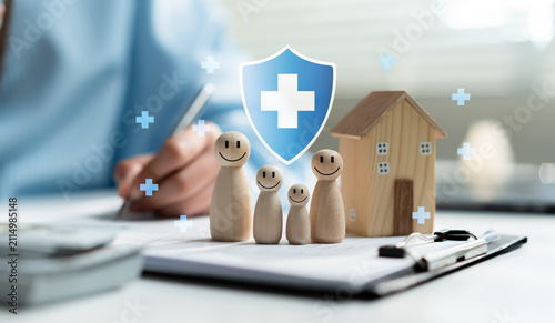 Foto Family health insurance concept with wooden figures, house model and medical shield icon on documents, symbolizing financial protection, healthcare coverage, home security and future planning
