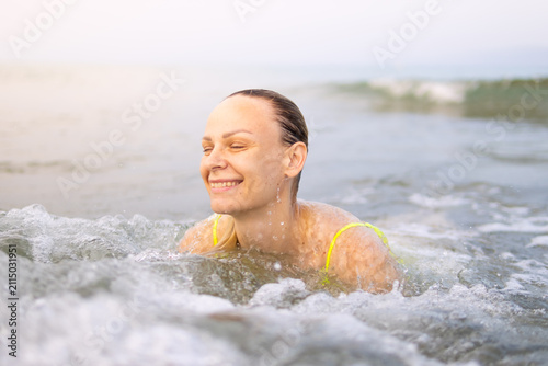 Photography Woman enjoying refreshing ocean waves, swimming and smiling with closed eyes, fe