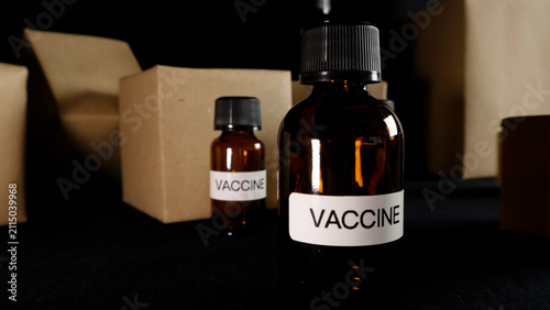 Cuadro en lienzo Vaccine bottles with labels showing VACCINE presented on a dark background, illu