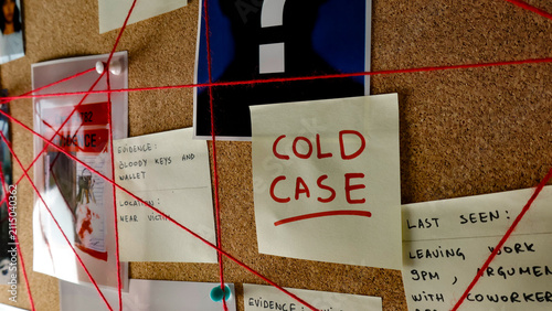Fotografie Cork board featuring interconnected notes, images, and red threads, representing
