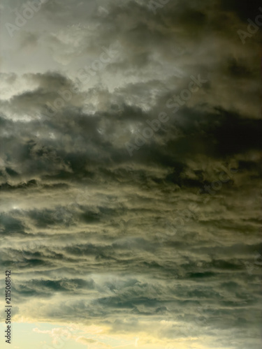 Dynamic cloudscape during golden hour in summer, with undersides of lowering clouds illuminated by sunlight in the evening sky, southwest Florida. Motifs of transition, outlook, yin and yang.
