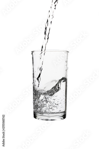 Fotografía Pouring fresh drinking water into a clear glass isolated on a white background