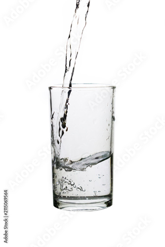 Cuadro en lienzo Pouring fresh drinking water into a clear glass isolated on a white background