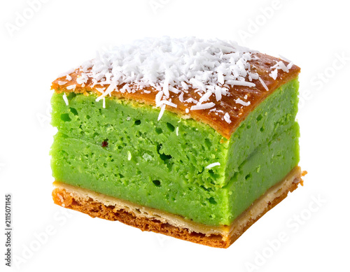 A single square slice of green pandan cake topped with shredded coconut flakes
