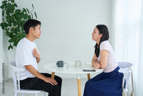 Japanese Man and Woman Talking Face to Face at Cafe Table