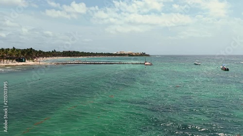 Aerial view of turquoise Caribbean sea ,sandy beach, pier with docked boats and palm trees in Playa del Carmen, Cancun, Mexico