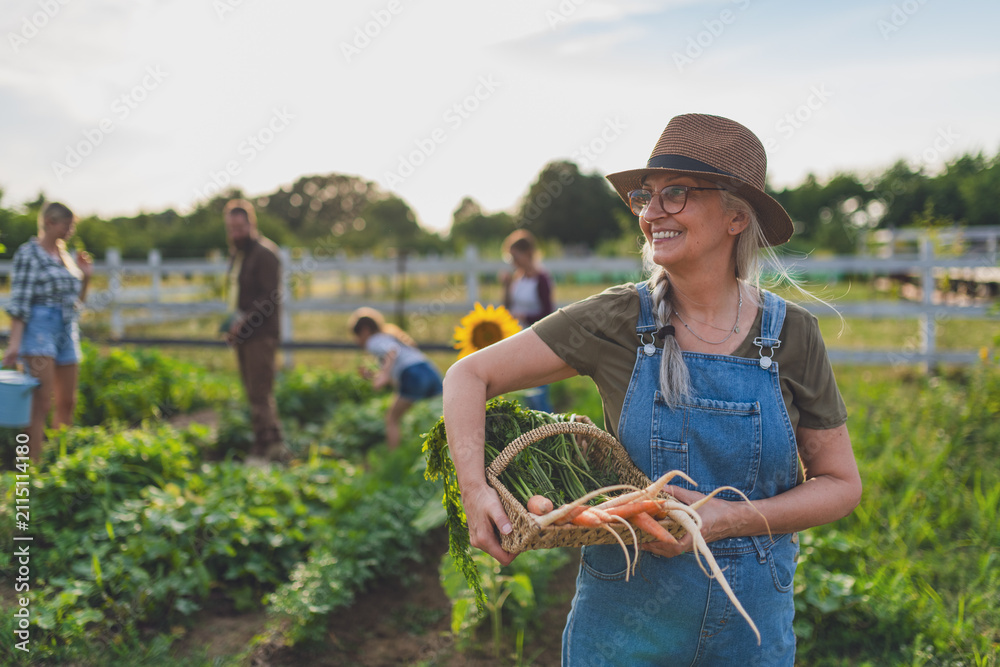 Obraz premium Happy farmers or gardeners working outdoors at community farm.