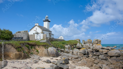 Phare de Pontusval lighthouse surrounded by granite rocks on the sandy coast of Brittany 