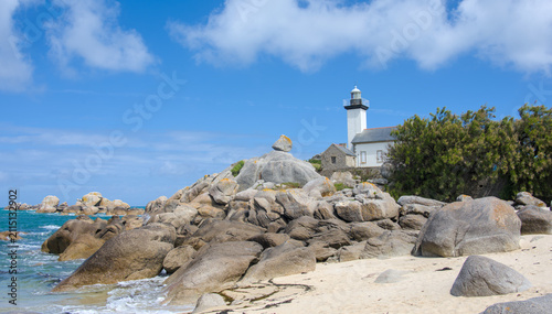 Phare de Pontusval lighthouse surrounded by granite rocks on the sandy coast of Brittany 