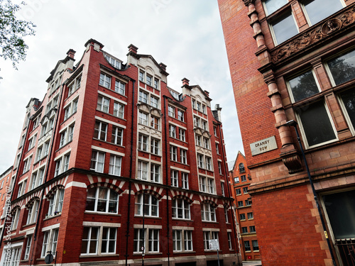фотографія Historic red brick building facade in Manchester, UK with ornate Victorian archi