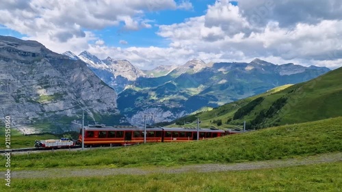 Swiss Cows with Cowbells and Red Mountain Train Switzerland Kleine Scheidegg Eiger Peak. Scenic Panorama Jungfrau Railway Snow Alps Landscape Travel Video 4K UHD with Natural Audio