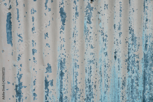 Weathered corrugated metal texture with peeling blue paint