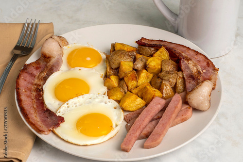 Fotografie three fried eggs  with spam fries and  bacon