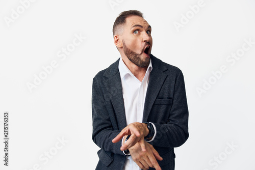 Obraz na plátně A professional man in business attire stands against a clean colored background, displaying a genuine surprise emotion