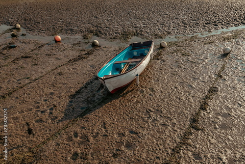 Fishing boat on the river Axe in Devon during low tide