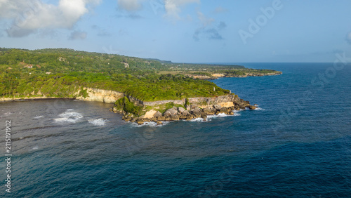 Aerial view of Cabo Frances Viejo, featuring lush green cliffs, dense vegetation, and turquoise waters meeting the Atlantic Ocean in Cabrera, Maria Trinidad Sanchez, Dominican Republic.