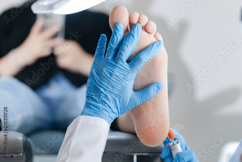 Bild auf Leinwand Podiatrist treating foot with tools in medical clinic setting, toenails pedicure