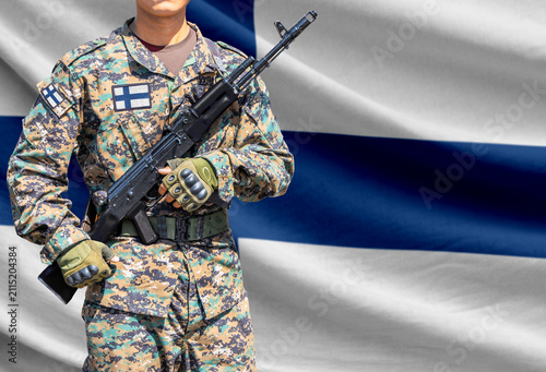 Фотография Finland flag with soldier holding assault rifle