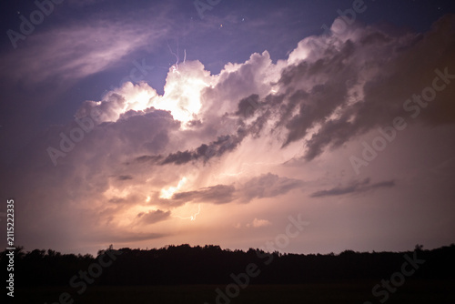 Heavy clouds bringing thunder, lightnings and storm. Thunderstorm flashes with multiple bolts of lightning.