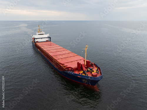 Fotografie Aerial view of a large commercial cargo ship navigating the Baltic Sea in Estonian territorial waters, proudly flying the local courtesy flag