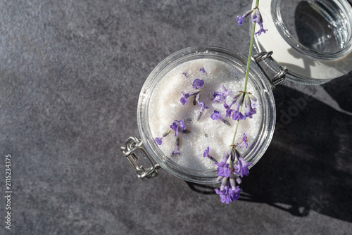 Homemade lavender sugar in glass jar with fresh lavender on stone background